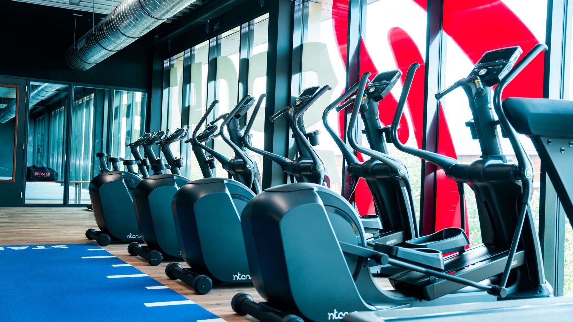 In een sportschool staan een aantal crosstrainers op een rij.