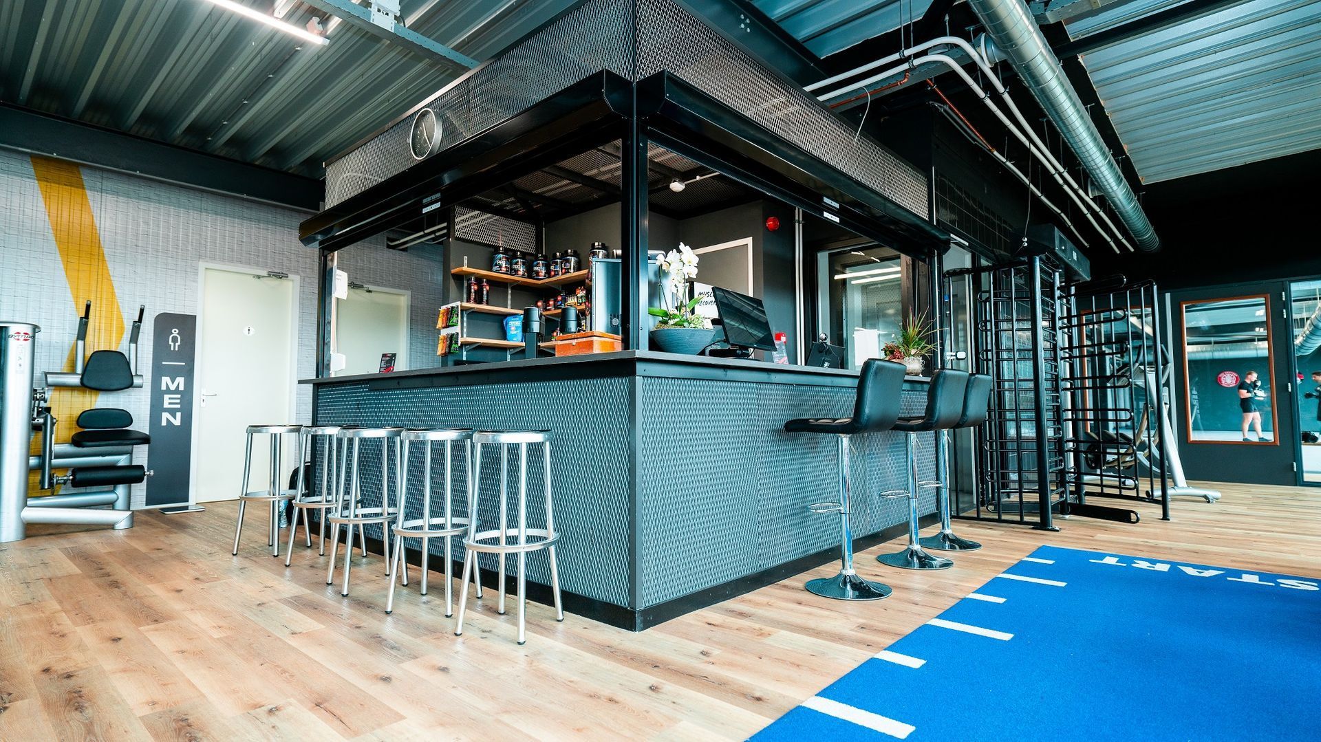 Een sportschool met een bar en krukken.