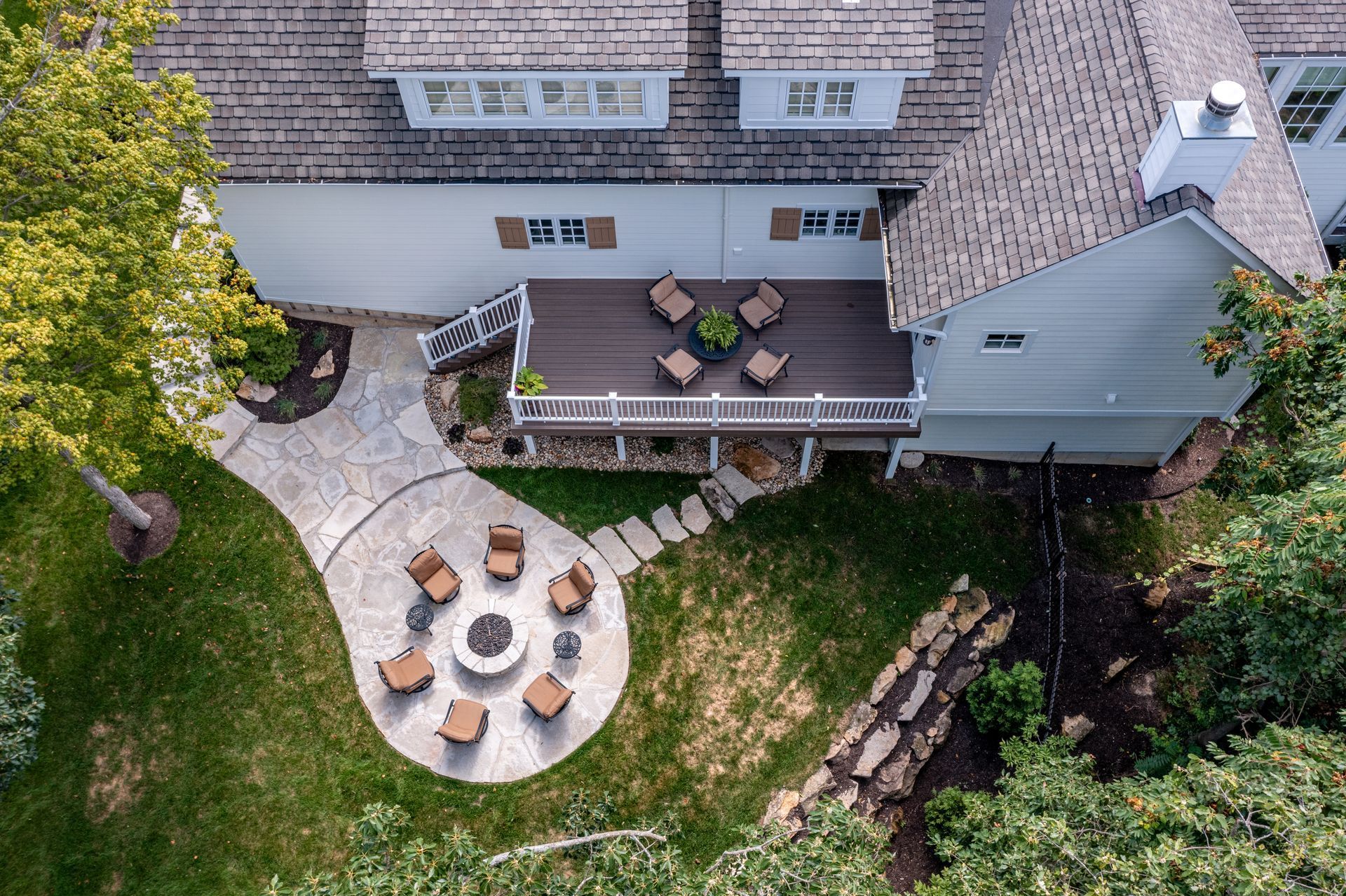 An aerial view of a house with a fire pit in the backyard.