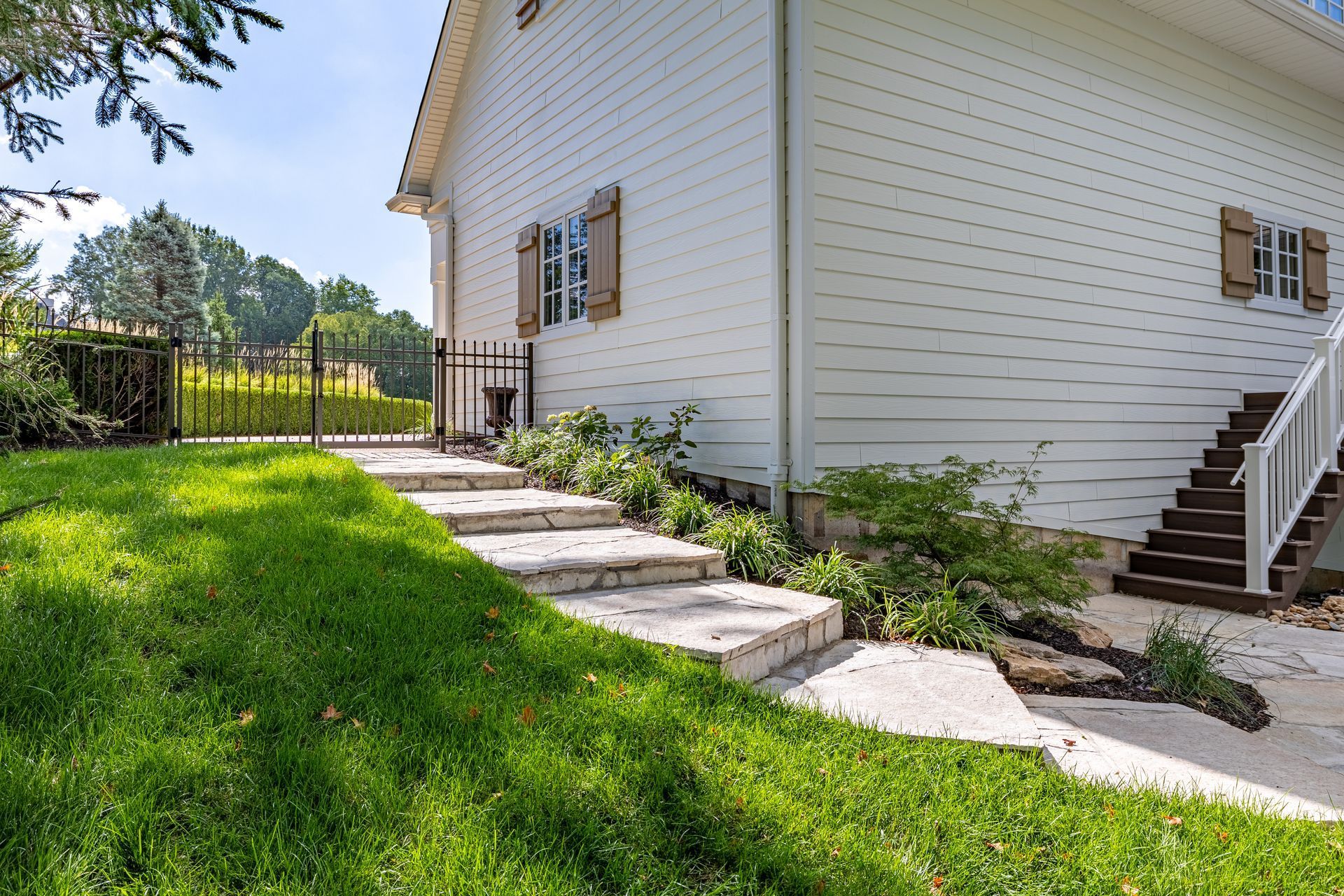 A white house with stairs leading up to the second floor.