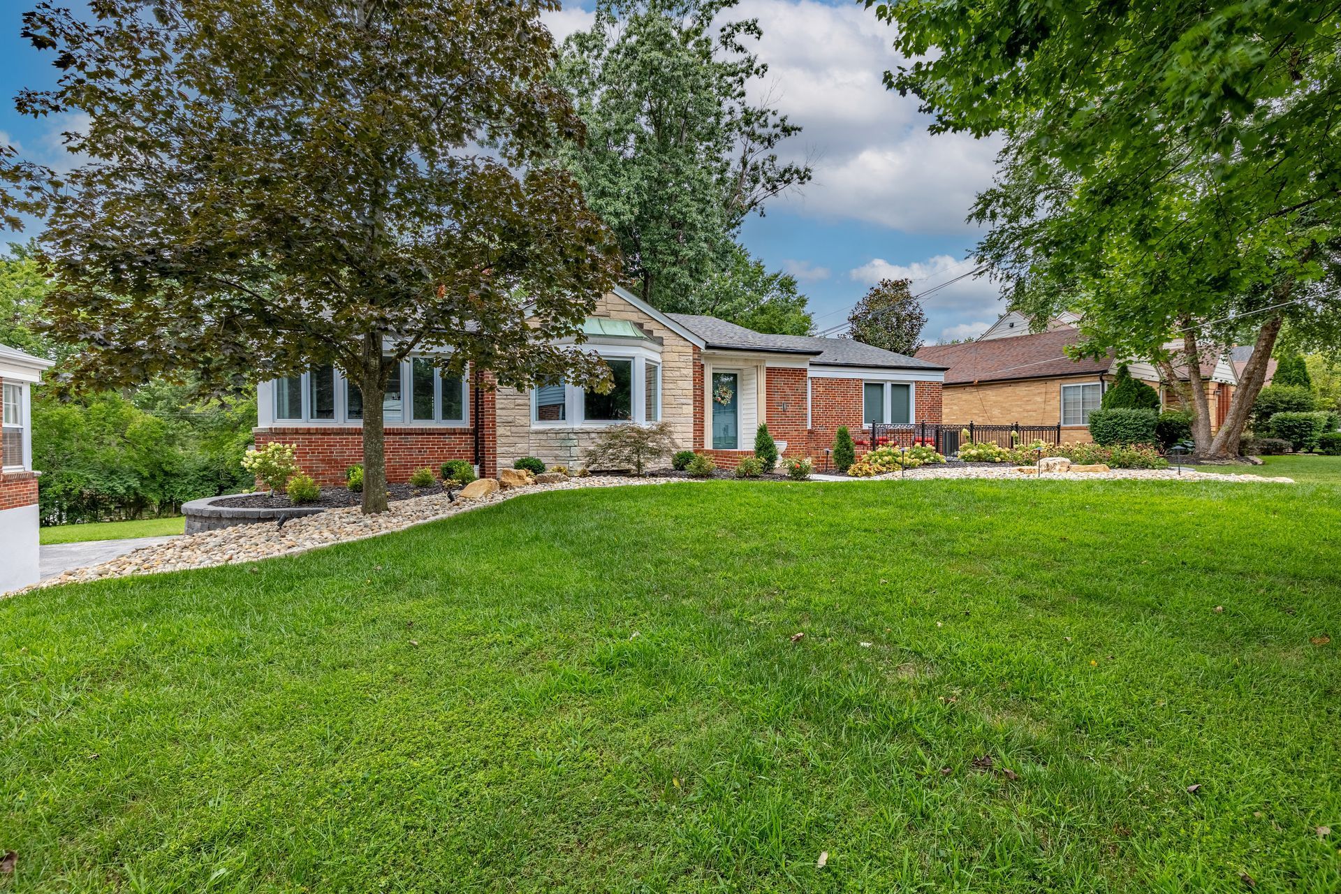 A house with a large lush green lawn in front of it.