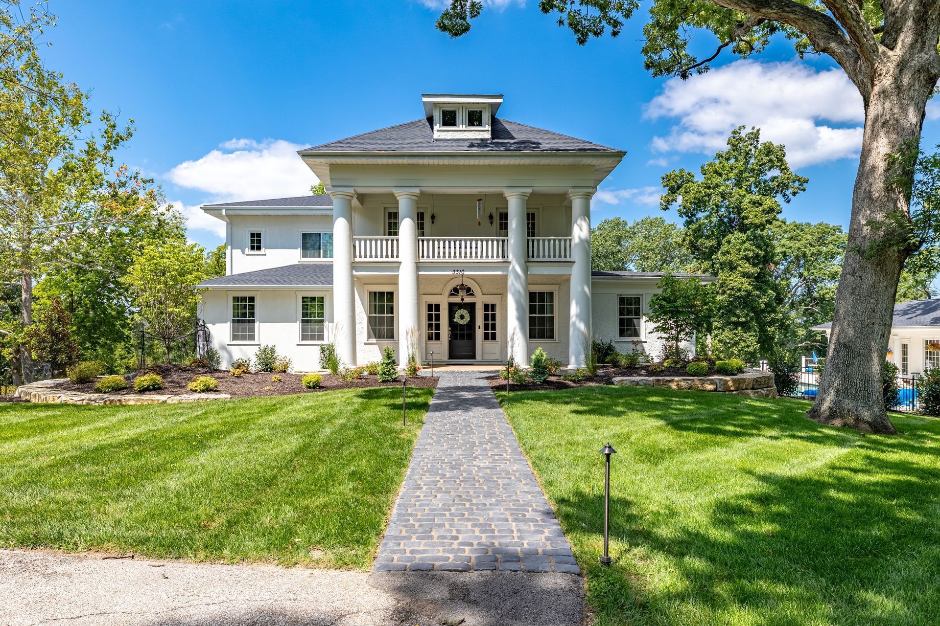 A large white house with a walkway leading to it