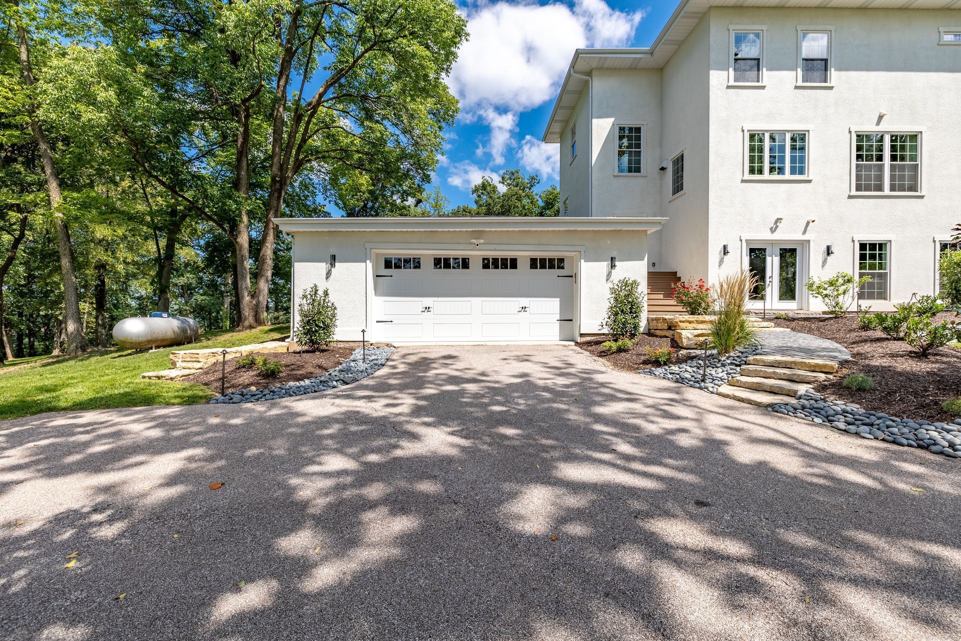 A large white house with a driveway leading to it and a garage.