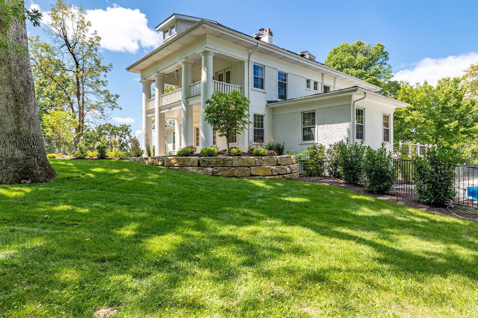 A large white house with a lush green lawn in front of it.
