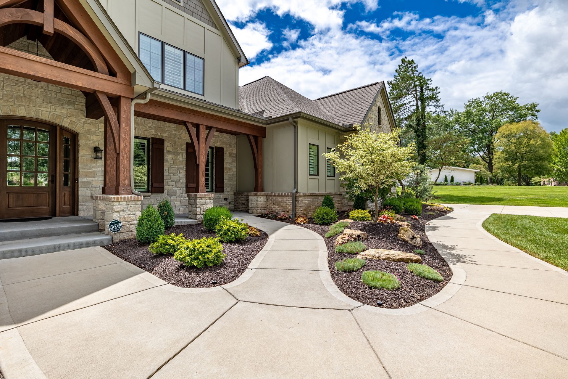 A large house with a concrete walkway leading to it.