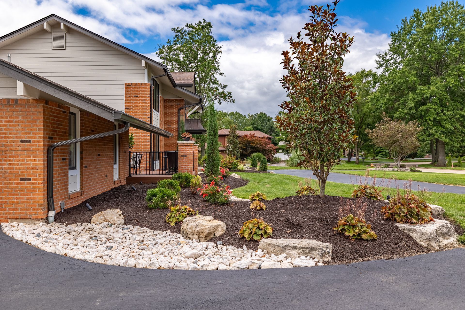 A brick house with a driveway leading to it