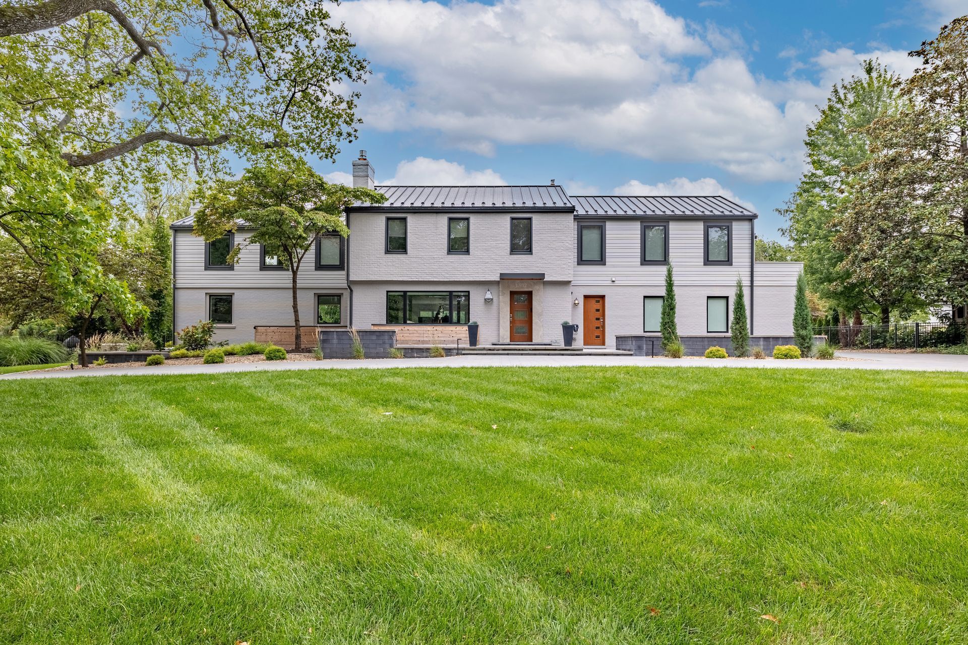 A large house with a lush green lawn in front of it.
