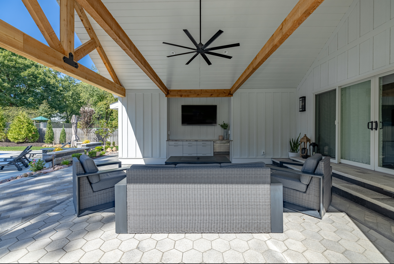 A living room with a ceiling fan and a television on the wall.