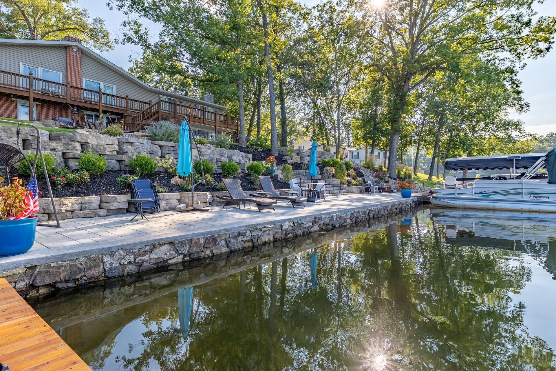 A dock with chairs and umbrellas next to a body of water.