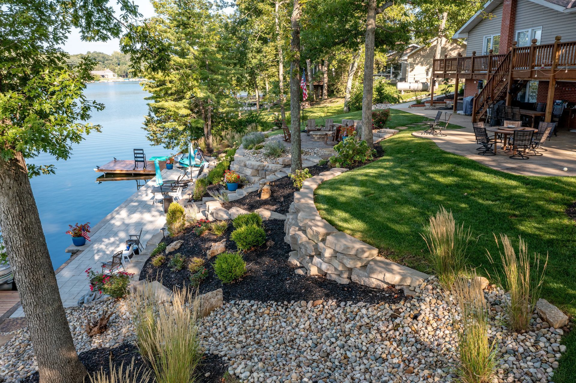 An aerial view of a house with a dock and a lake in the background.