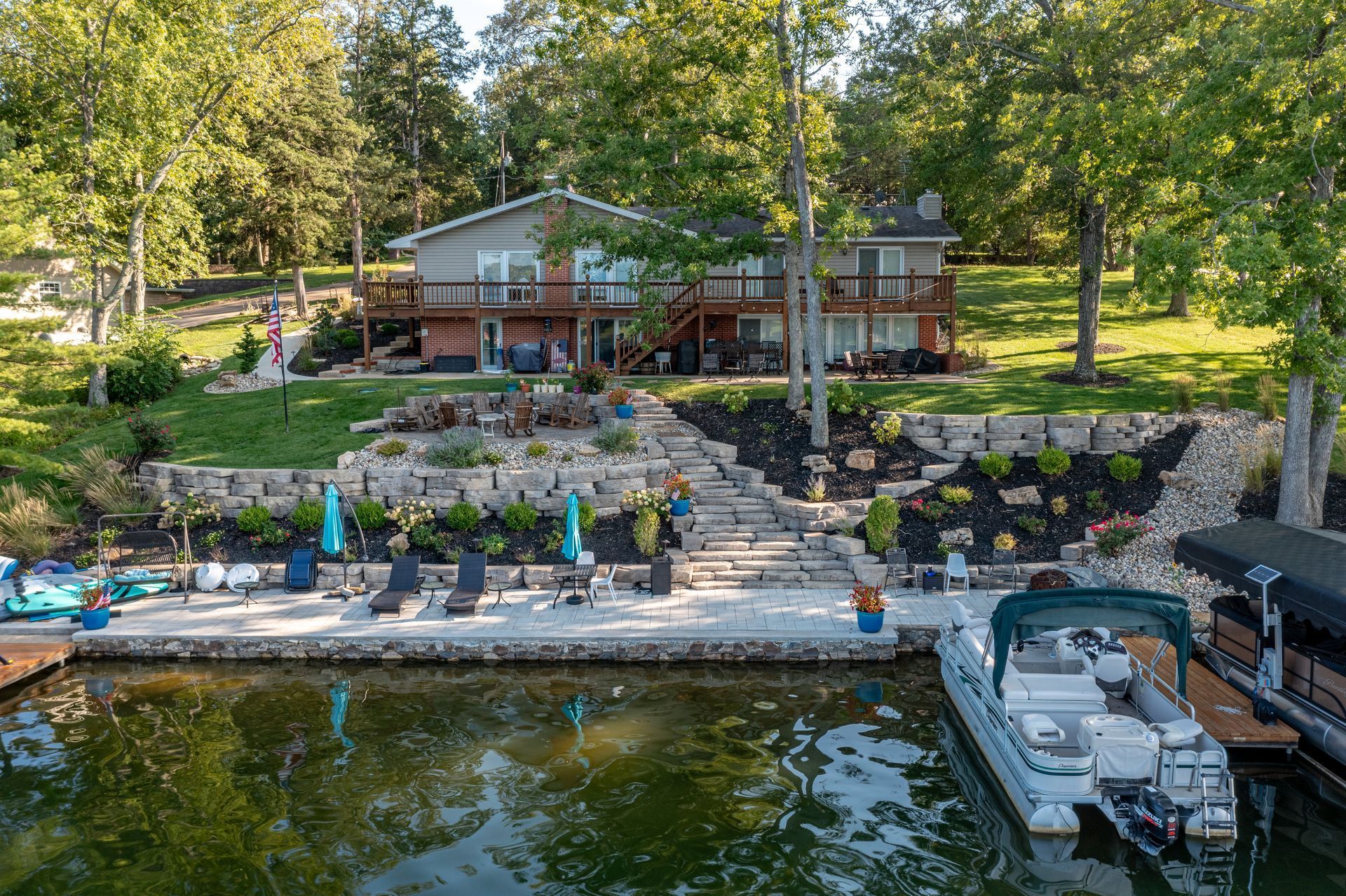 An aerial view of a house on a lake with a boat docked in front of it.