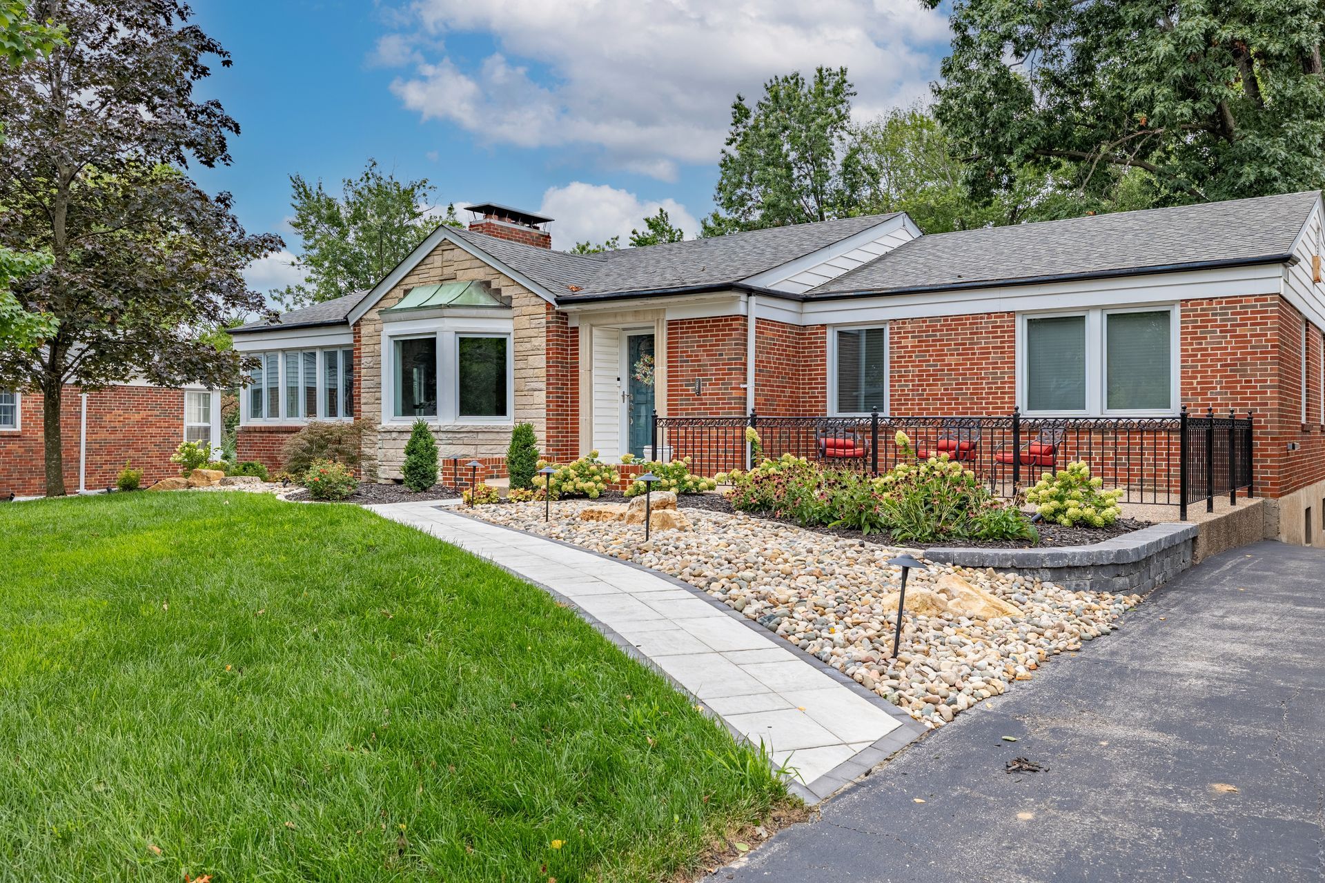 A brick house with a walkway leading to it is for sale.