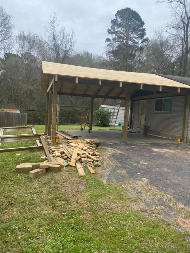 Carport construction with unfinished roof; wood beams and scraps on the ground.
