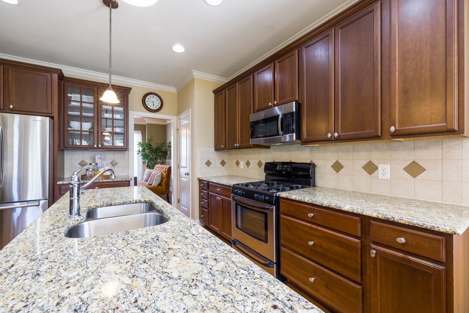 Kitchen with granite countertops, dark cabinets, stainless steel appliances, and a central island.