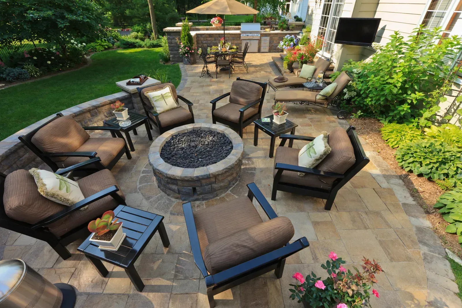 Patio with fire pit surrounded by chairs, a grill area, and lounge seating.