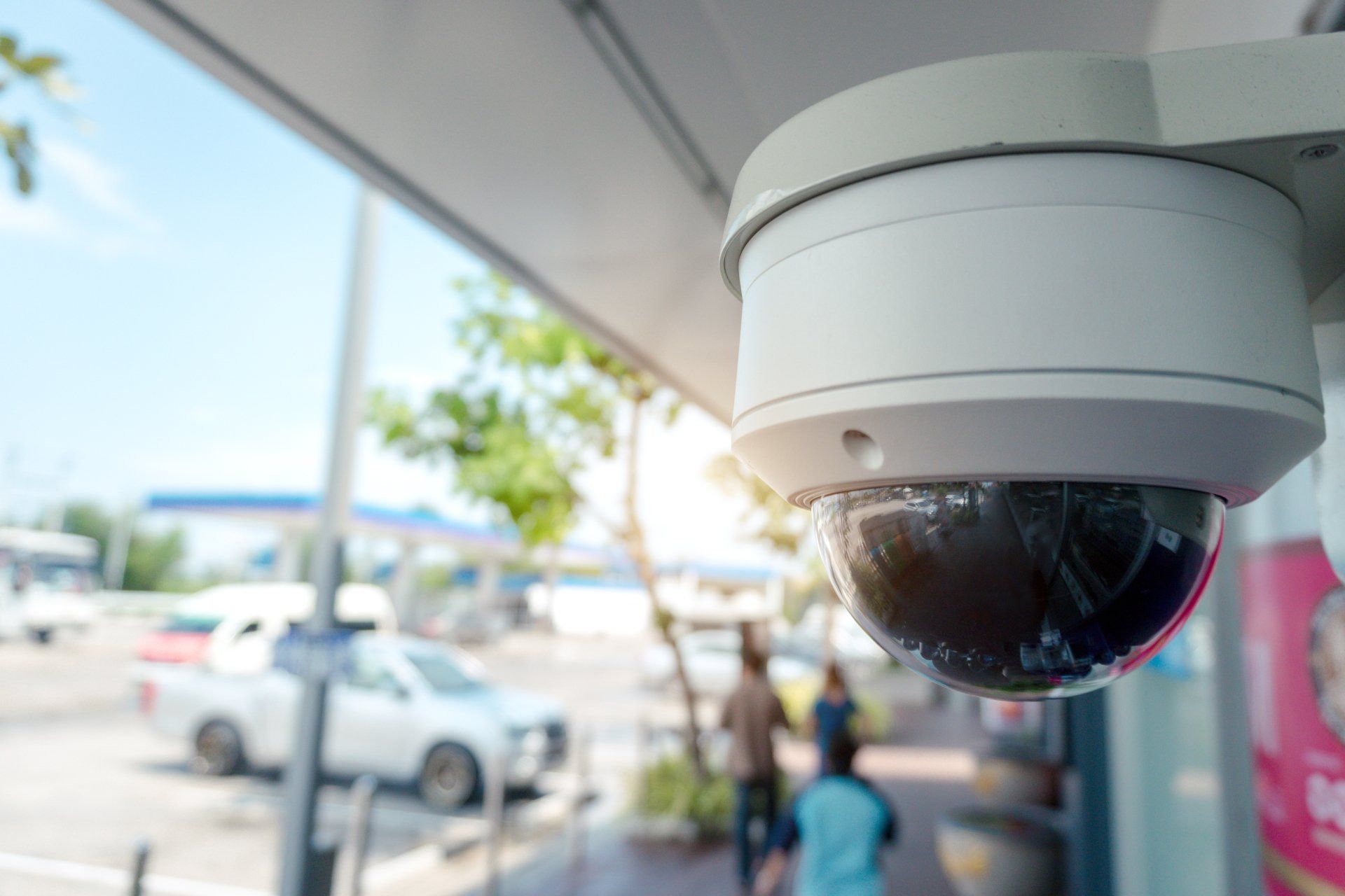 A security camera is hanging from the ceiling of a building.