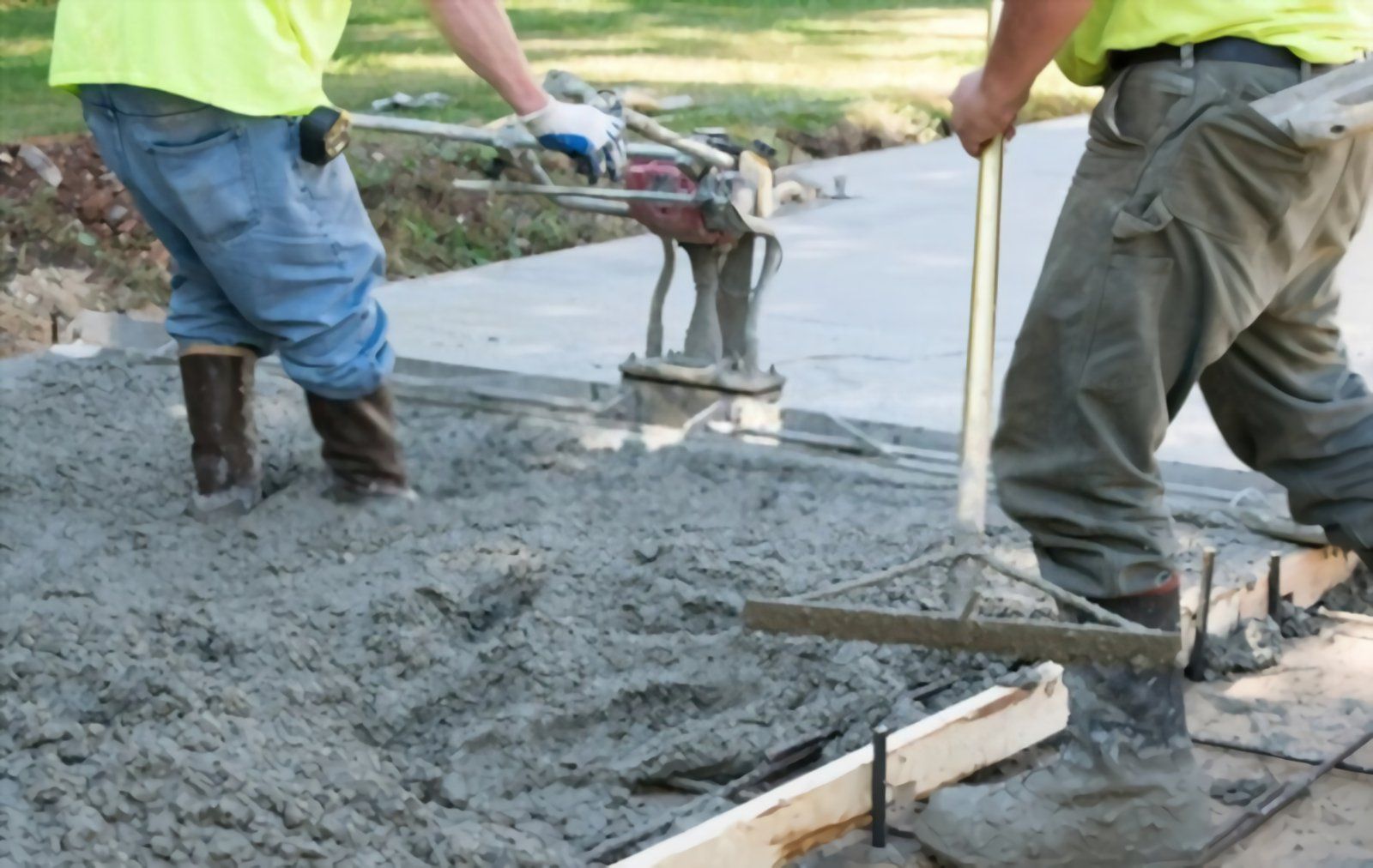 Local contractor using a concrete vibration leveler to smoothen the surface