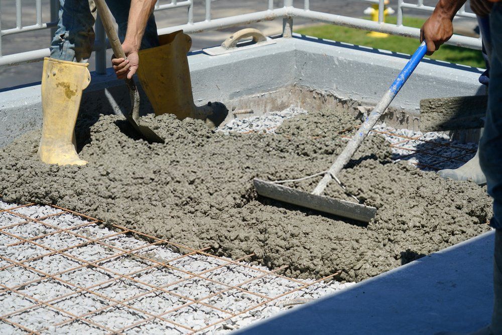 Naples Concrete Solutions pros spreading concrete around the frame