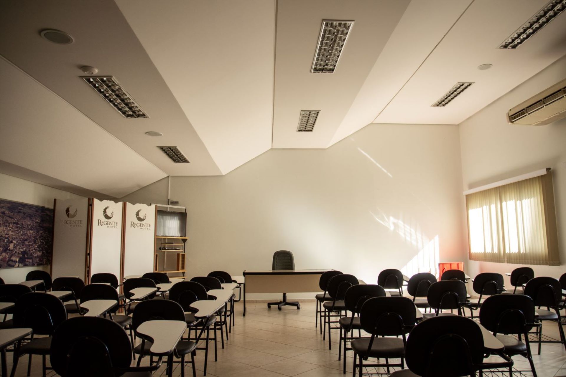 Uma sala de aula vazia com mesas e cadeiras