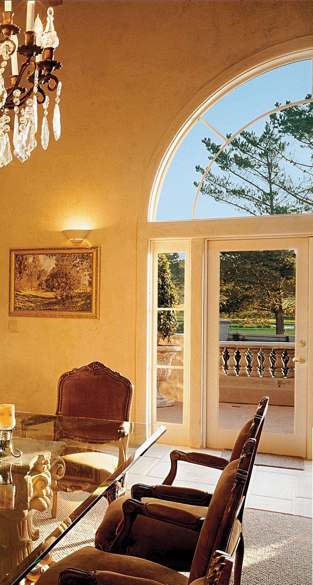 A dining room with a table and chairs and a chandelier