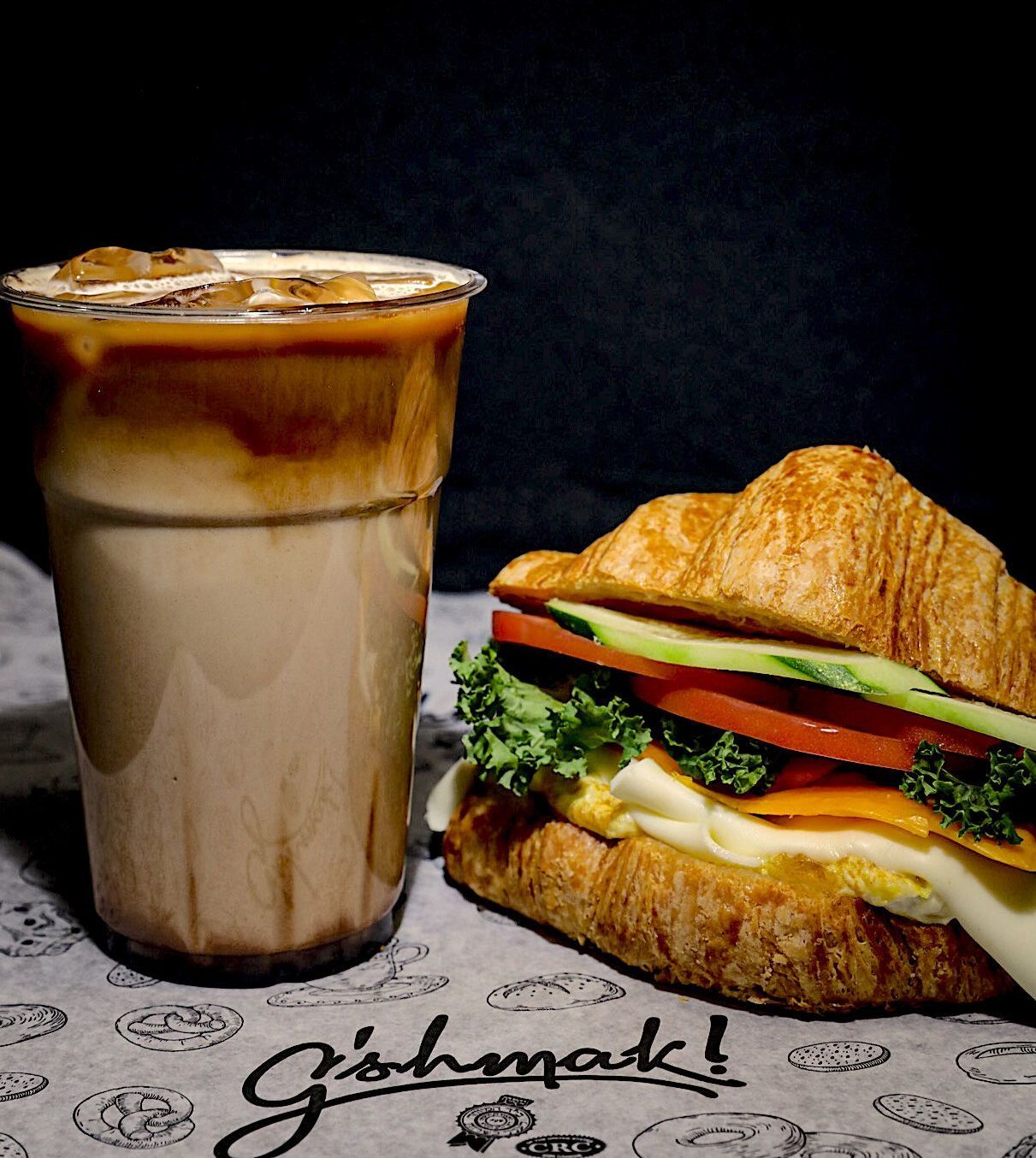 A sandwich and a cup of coffee are on a table.