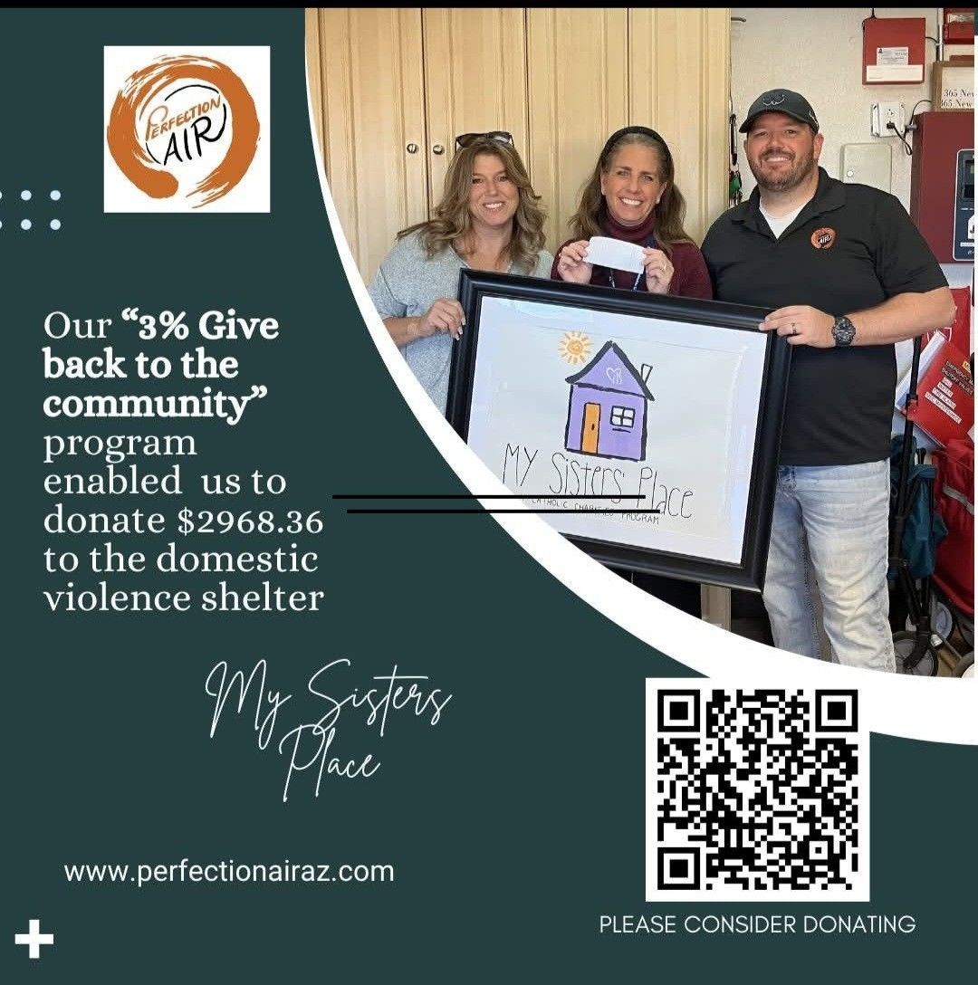 An air conditioner is sitting on the side of a brick building next to a flower.