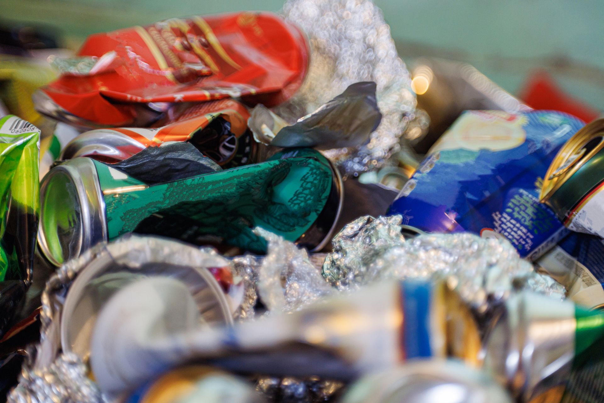A close-up of a pile of foil and crumpled tin cans highlights the importance of recycling A close-up of a pile of foil and crumpled tin cans highlights the importance of recycling