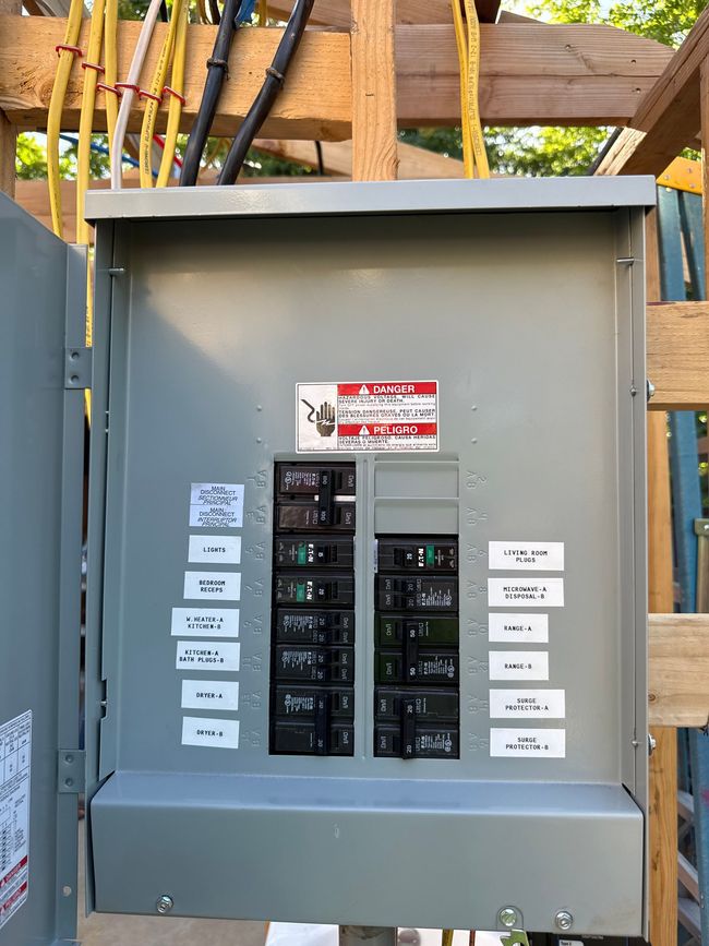 Man in blue plaid shirt changing a lightbulb in a decorative ceiling fixture.