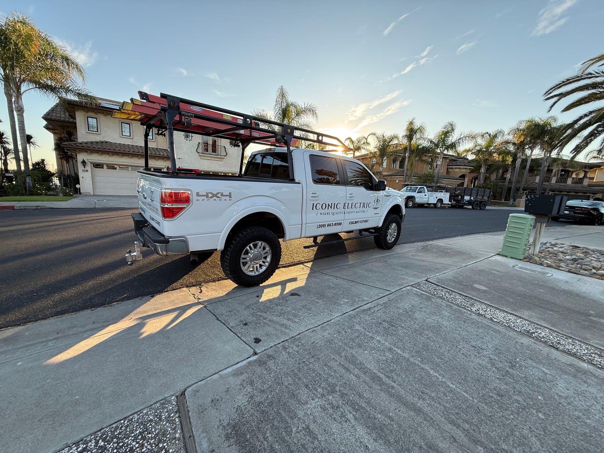 Electrician in safety gear working on a circuit breaker panel.