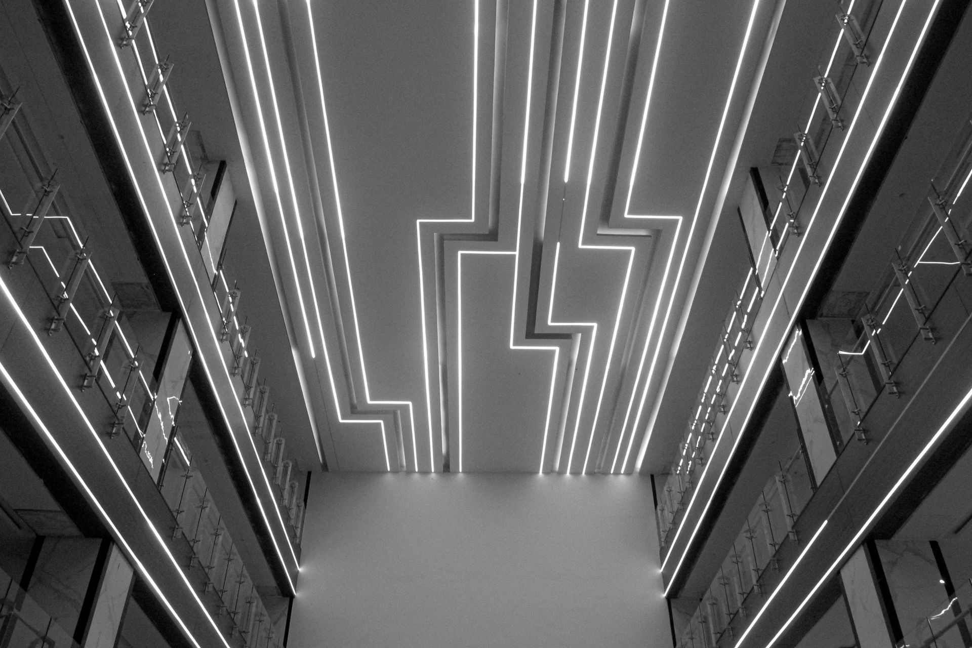 Bright linear lights on ceiling, illuminating a multi-story building interior.