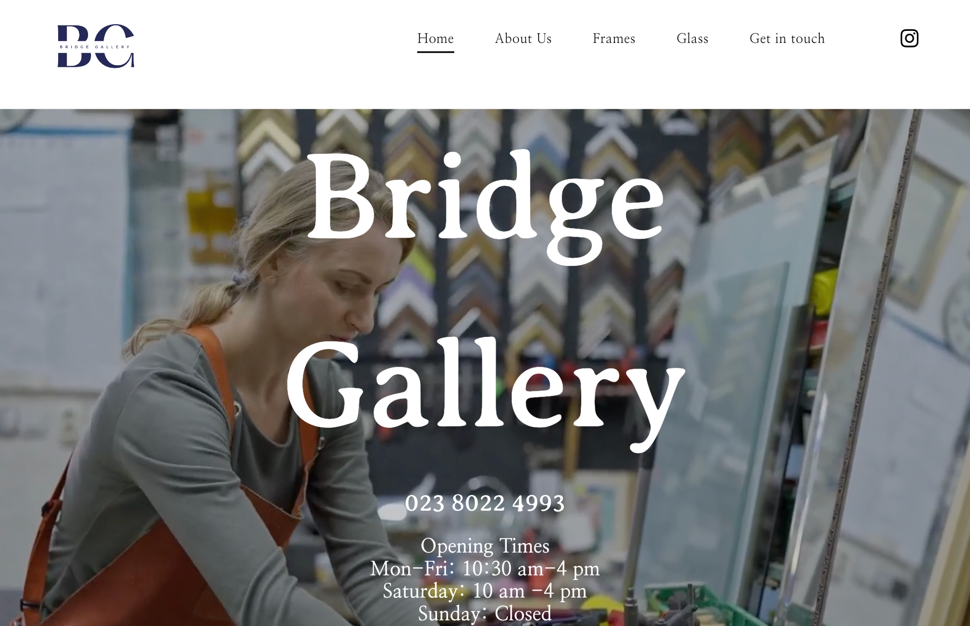 A woman is painting on a canvas in a bridge gallery.