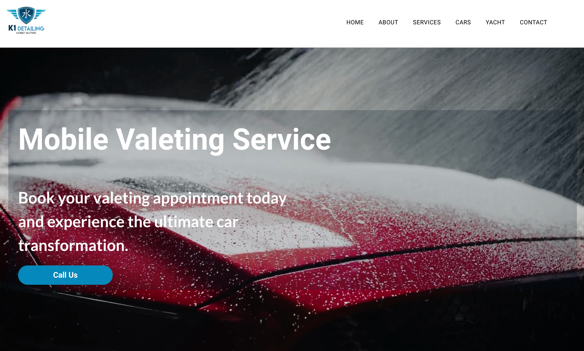 A red car is being washed by a mobile valet service.