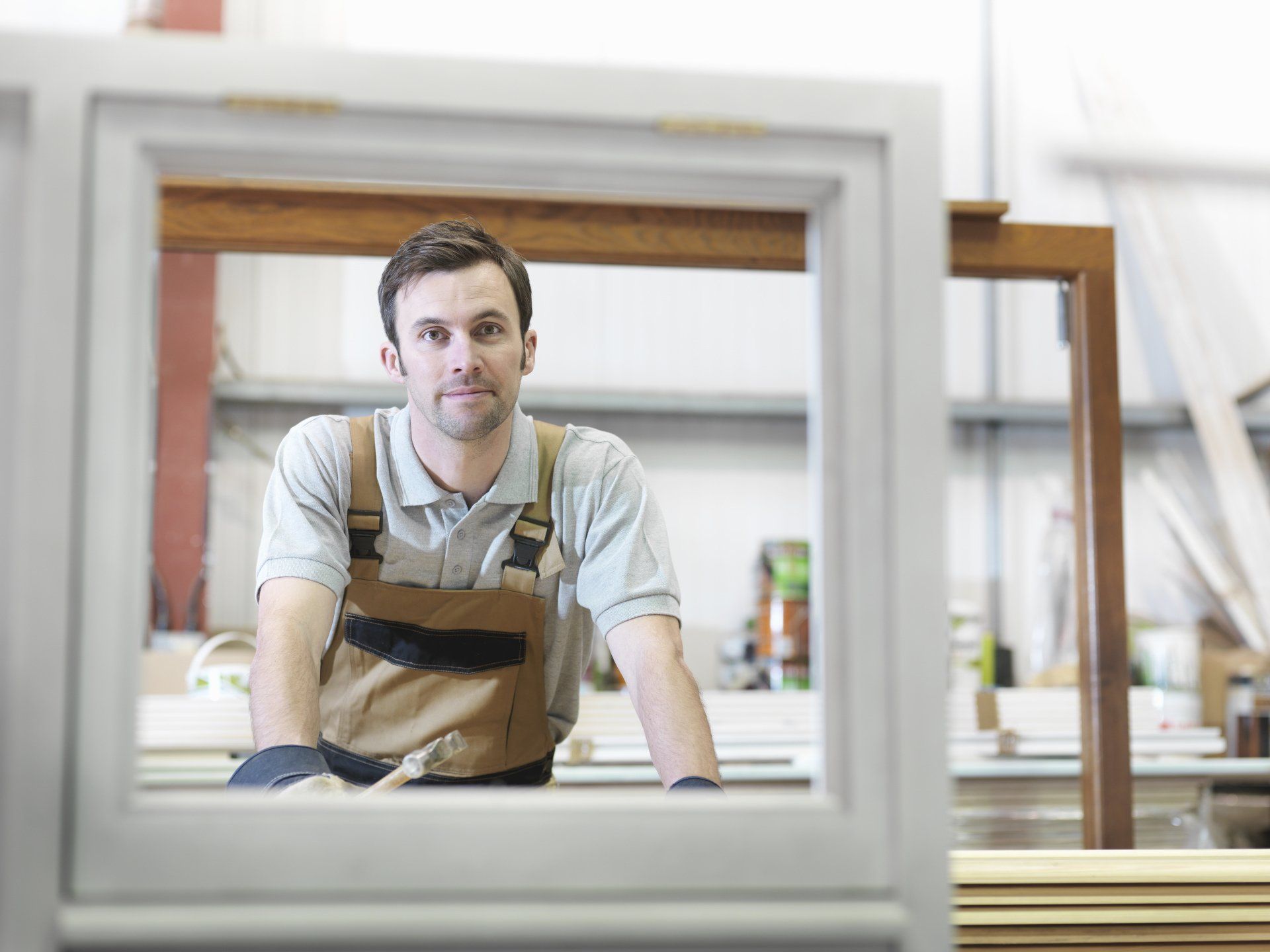 Carpenter looking through a newly made window frame