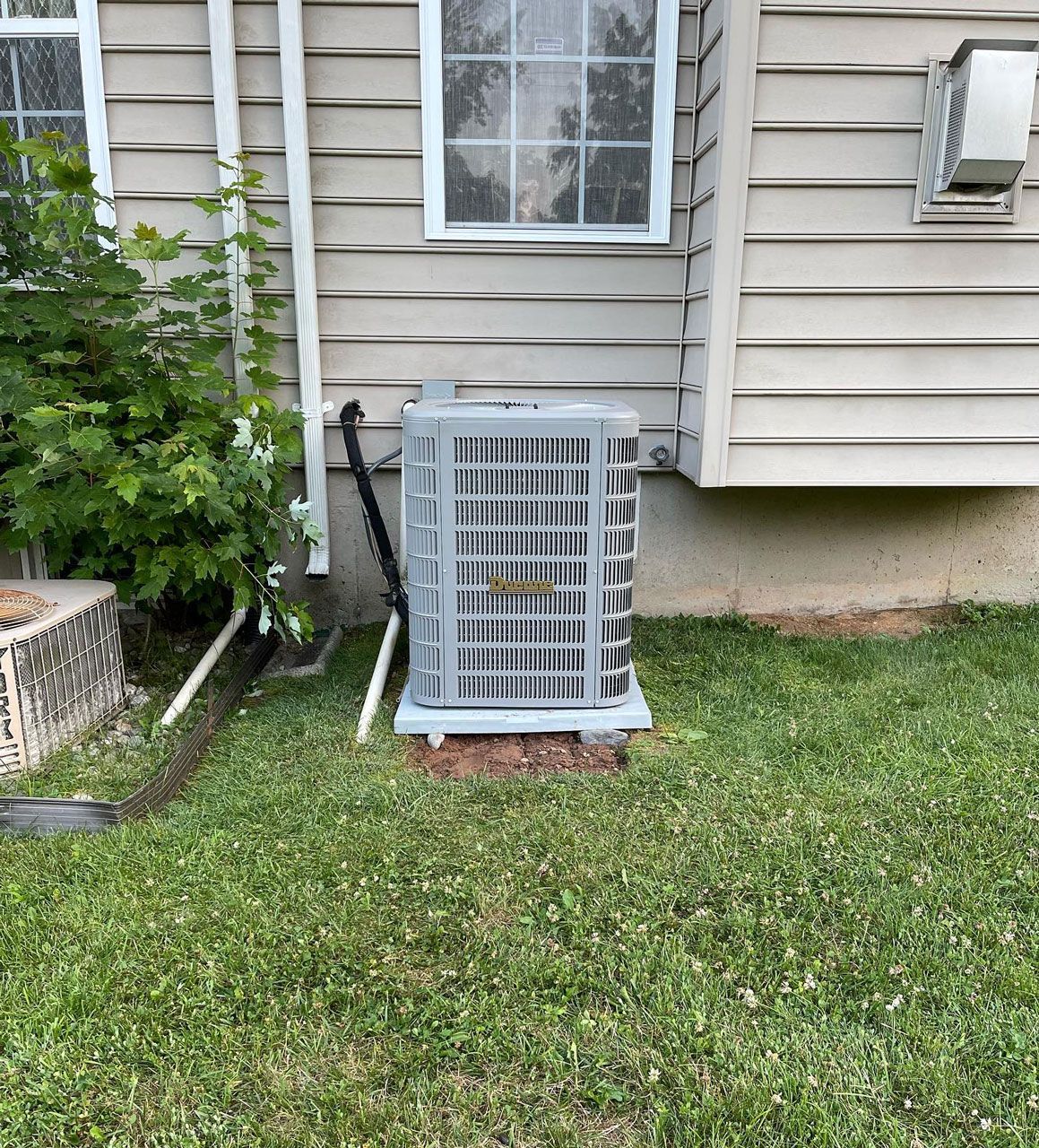Air conditioner in front of a house — Bensalem, PA — D.N.A Heating & Air