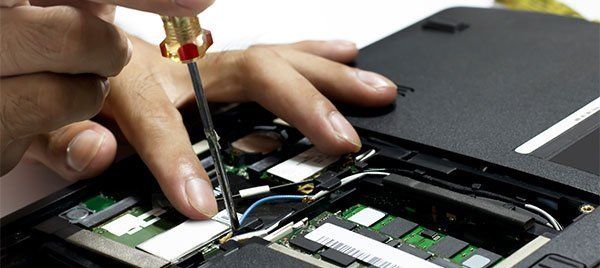 Man inrepairing a laptop using screw driver