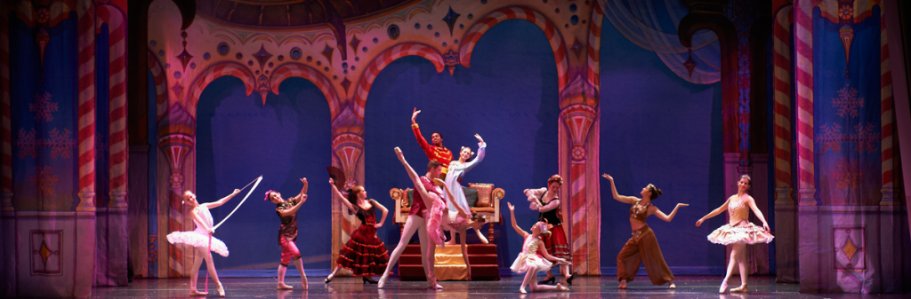 A group of ballet dancers are performing on a stage.