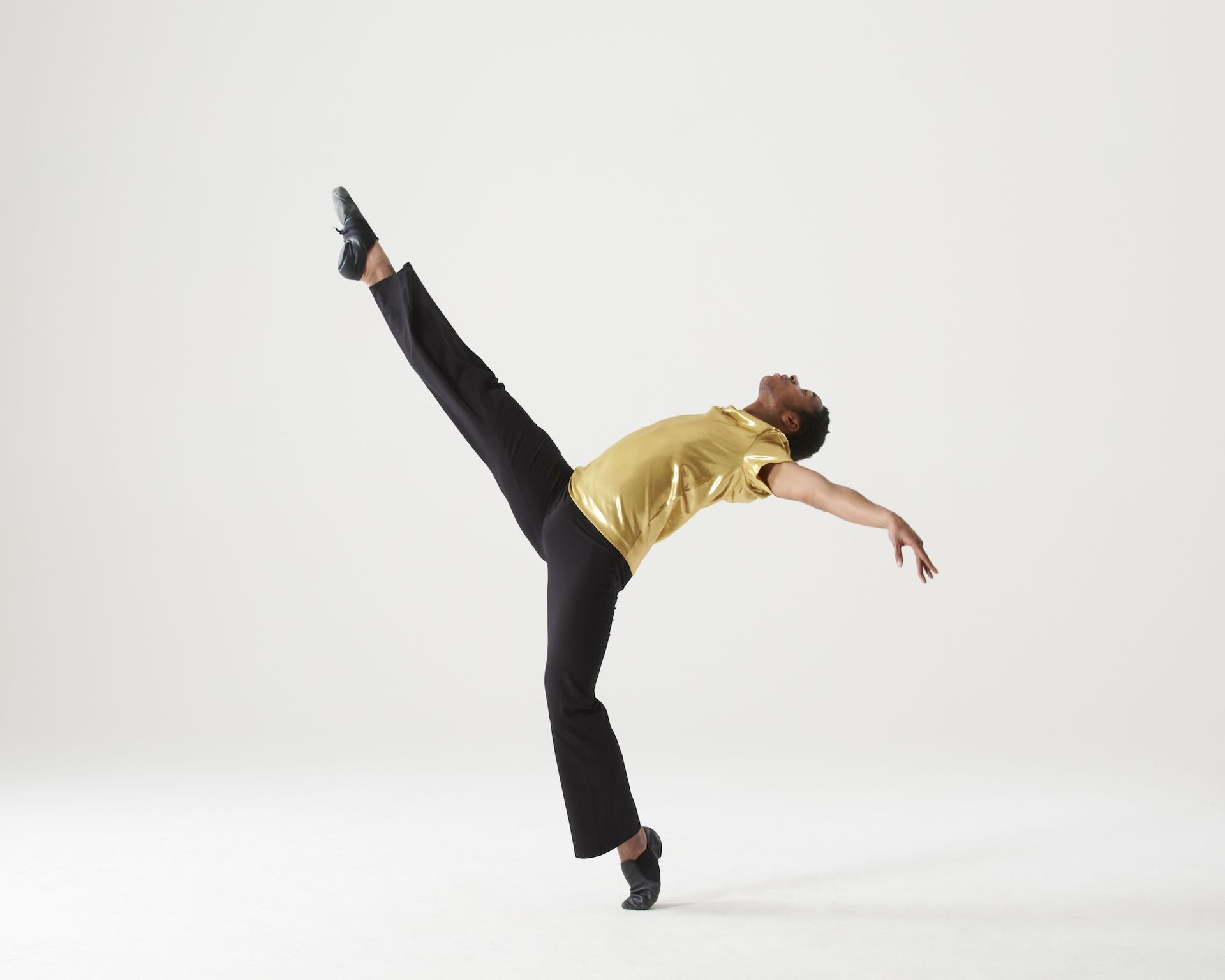 A man in a yellow shirt and black pants is dancing