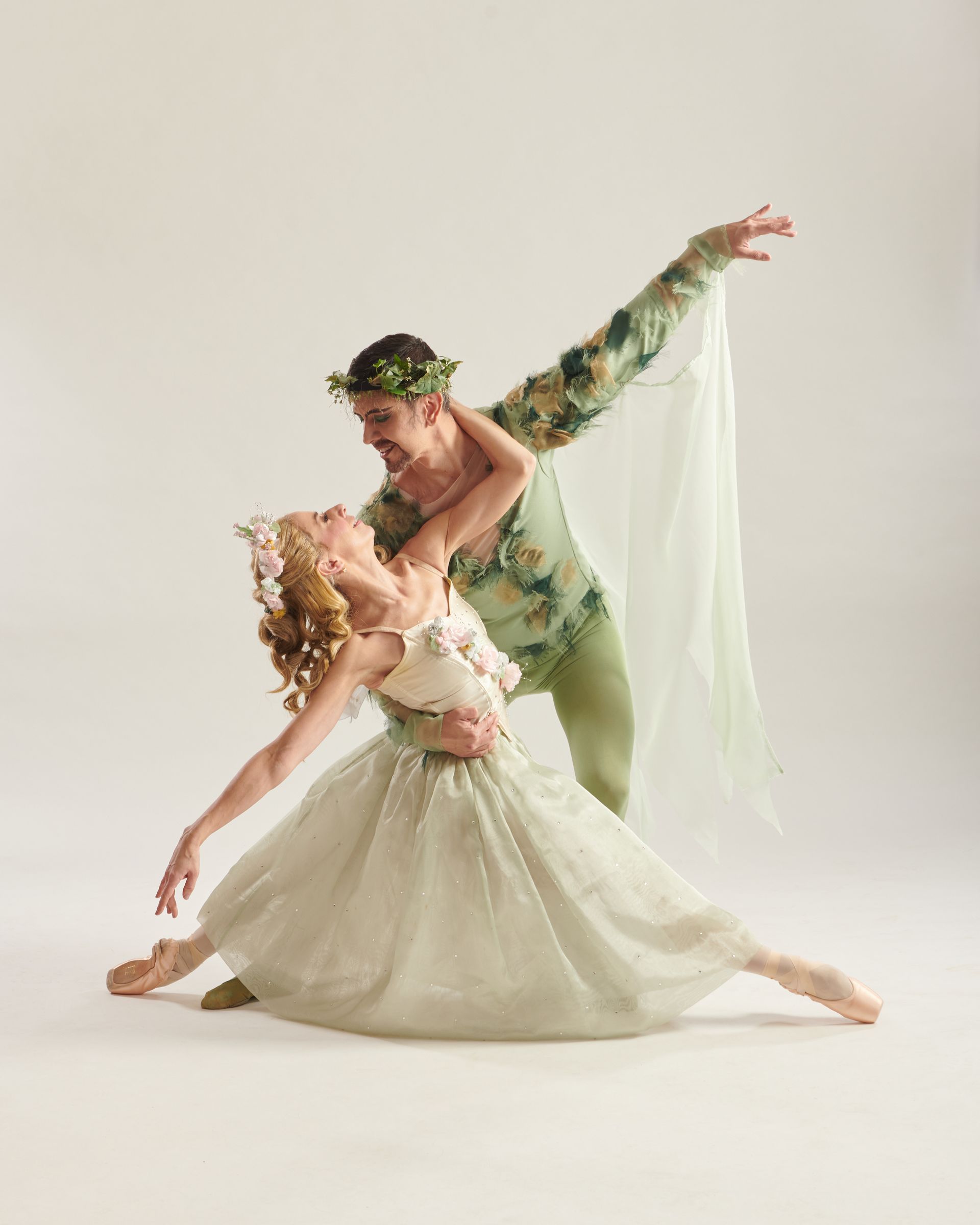 A man and a woman are dancing together on a white background.