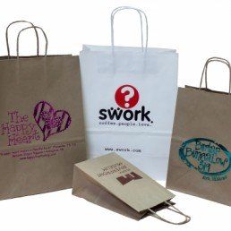 Three paper bags with one that says swork on it
