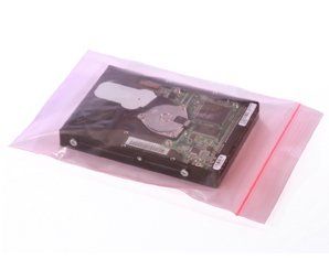 A hard drive is sitting inside of a pink plastic bag.