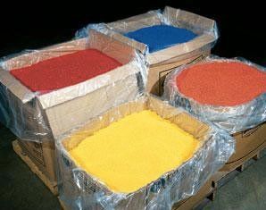 Three boxes filled with different colored powders are sitting on a pallet.