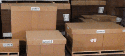 Several cardboard boxes are stacked on top of each other on wooden pallets.