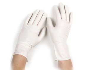 A pair of white latex gloves on a person 's hands.