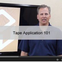 A man is standing in front of a large screen that says tape application 101