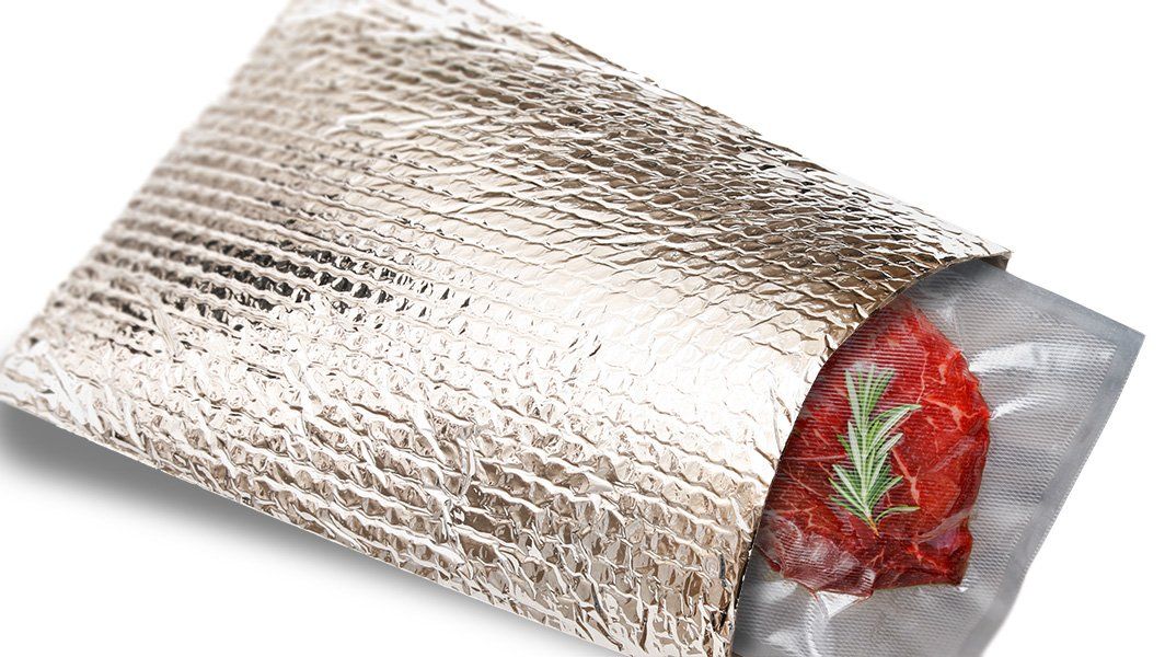 A piece of meat is wrapped in an aluminum foil bag.