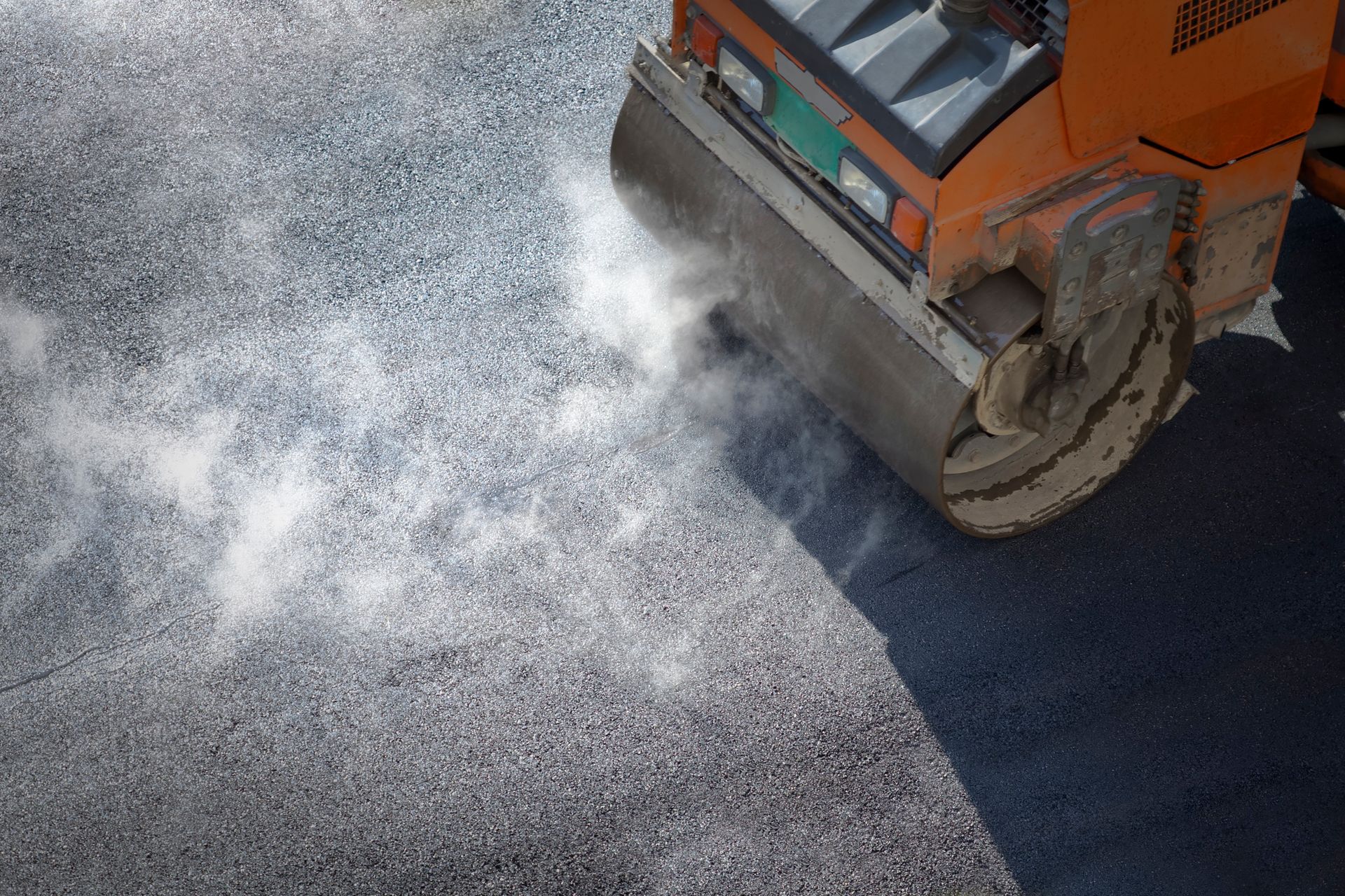 A roller compacting asphalt on a road.