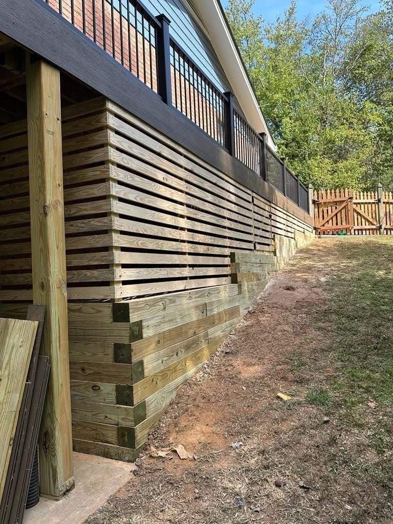 A wooden fence is being built around a house.