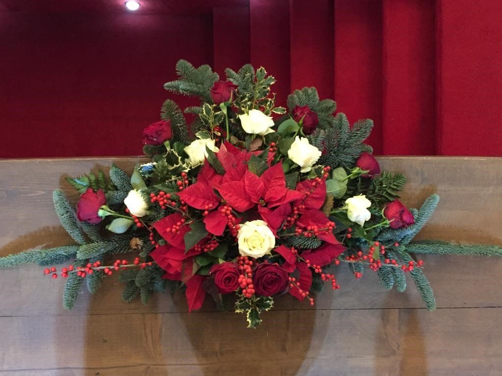 rose rosse e bianche con rami di pino