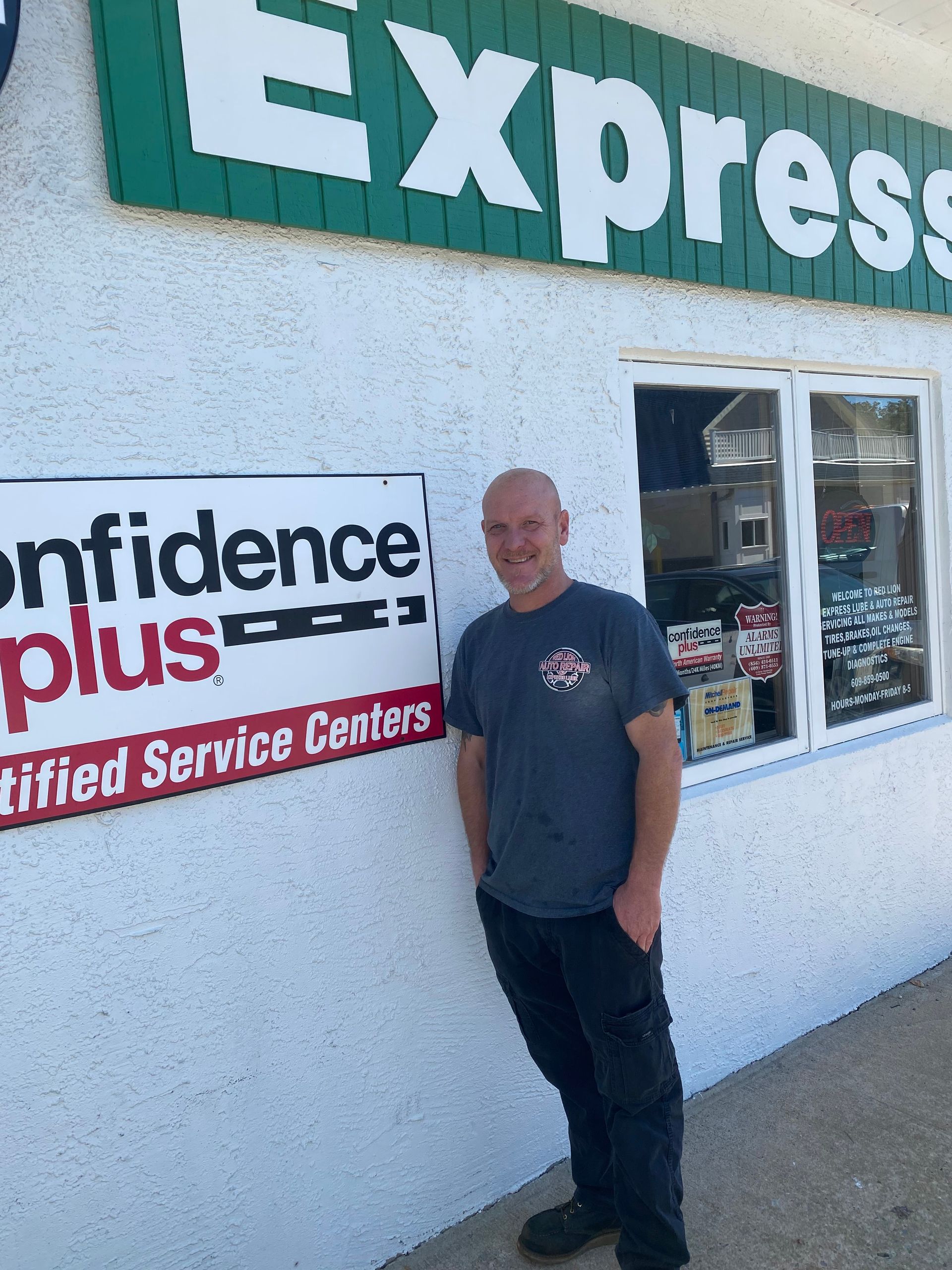 mechanic in front of shop | Red Lion Express Lube And Auto Repair