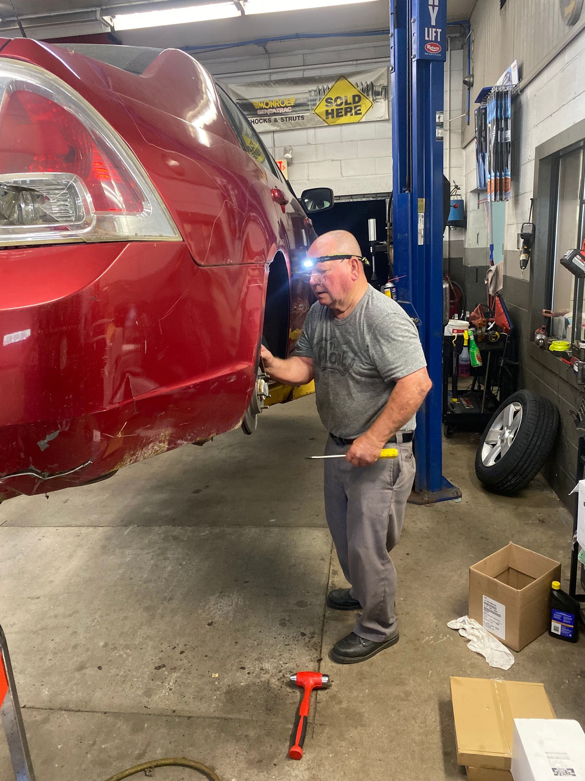 mechanic working on red car | Red Lion Express Lube And Auto Repair